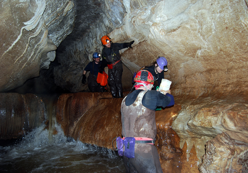 Group Climbing Down Rimstone